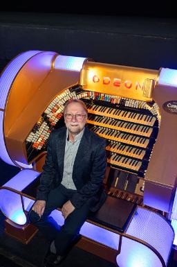 Man seated infront of movie theatre organs